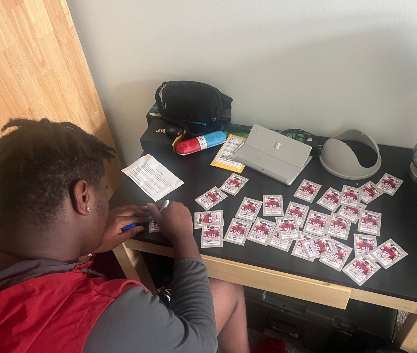 Jackson Pruitt signing trading cards.