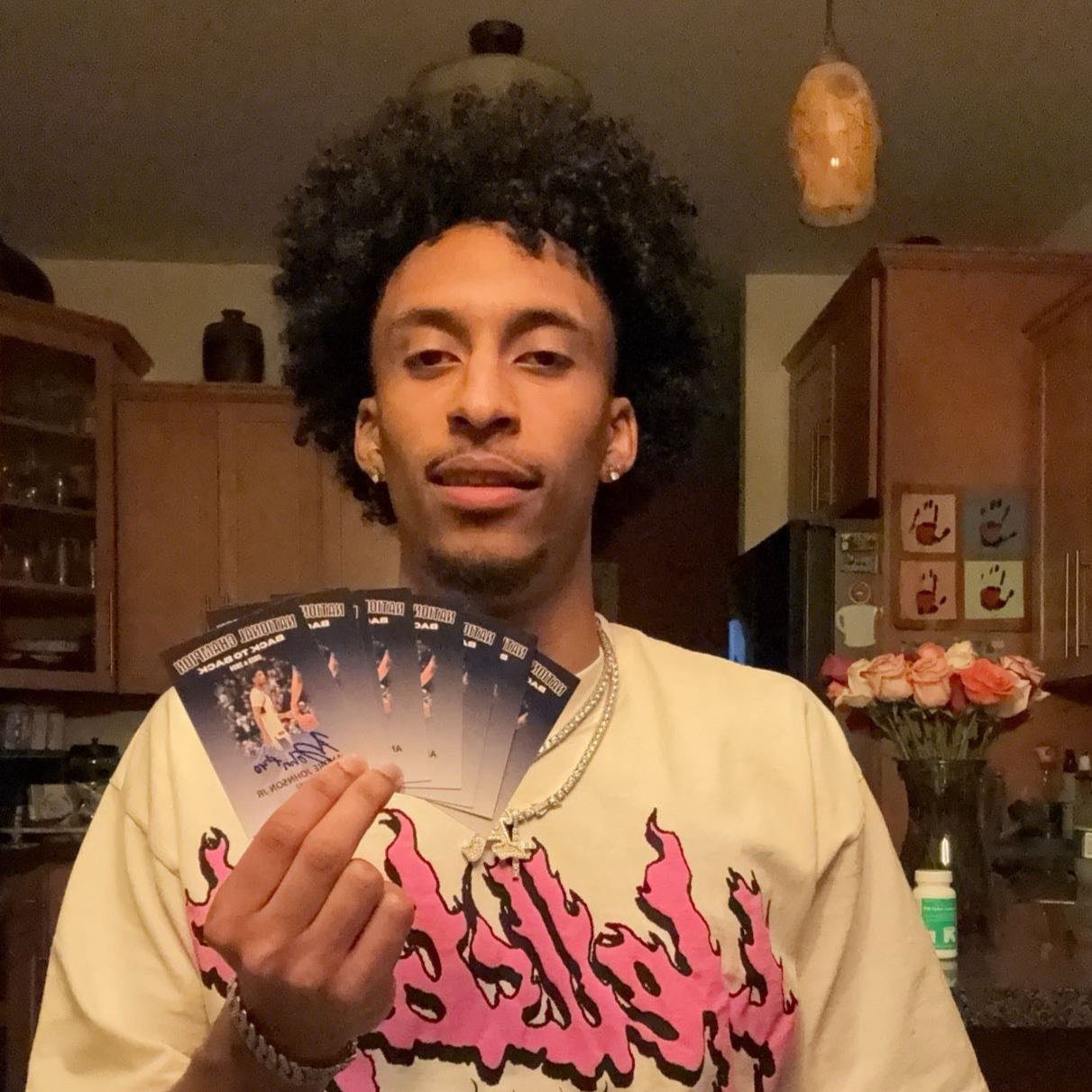 Andre Johnson Jr. holding his autographed trading cards.