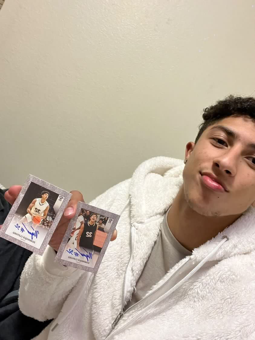 Dominique Clifford holding his autograhed trading cards.