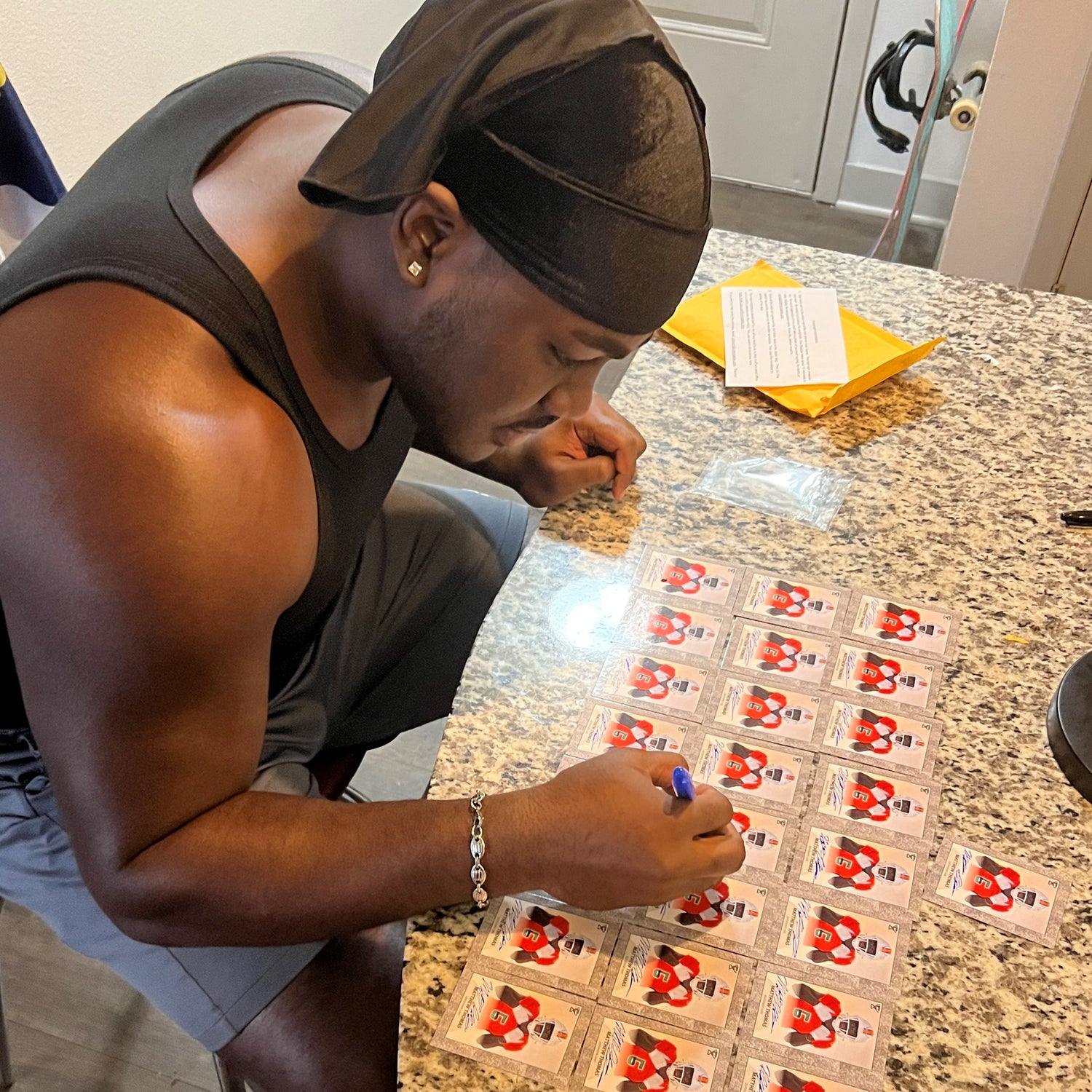 Matthew Thomas signing trading cards.